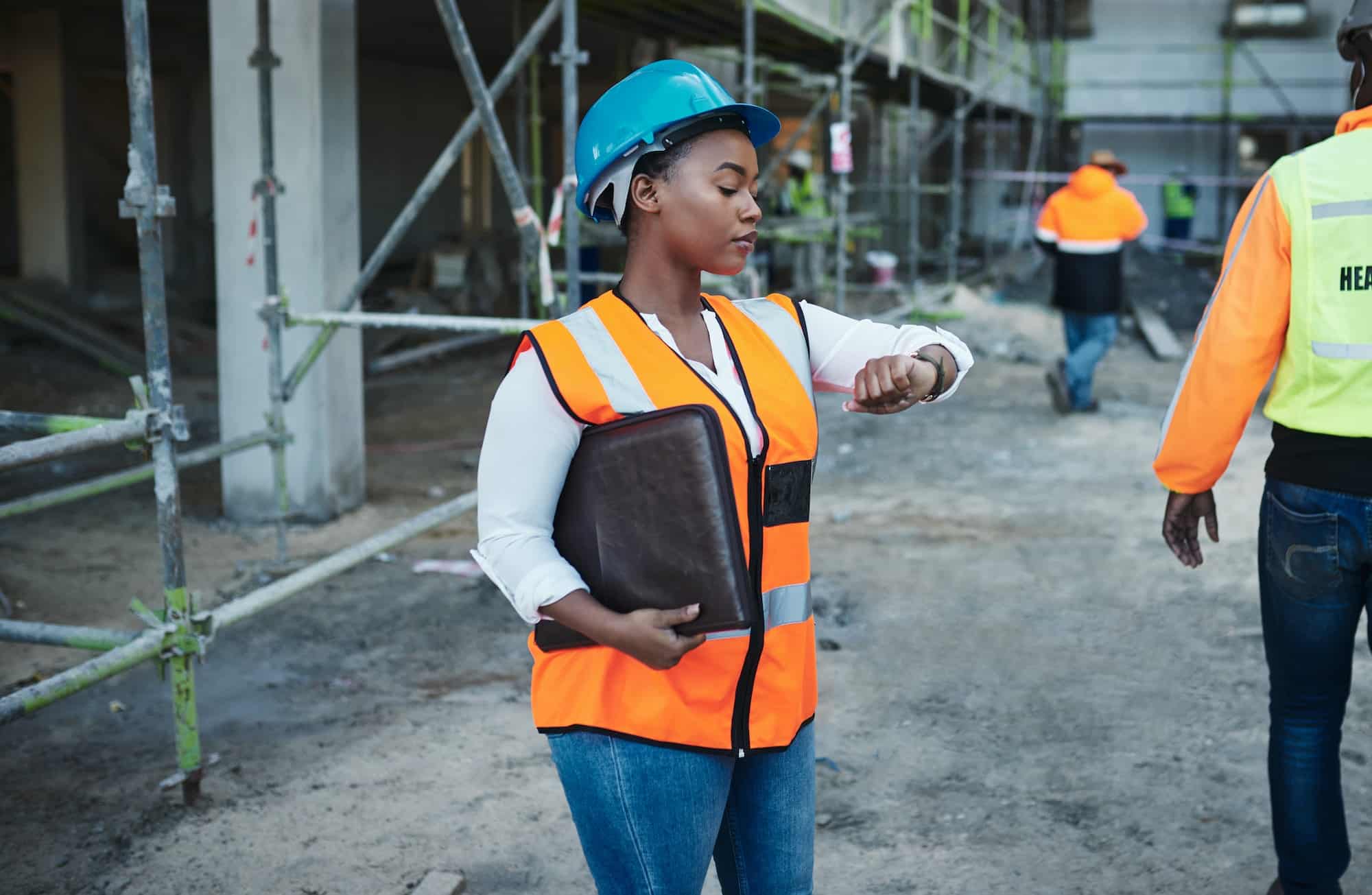 Shot of a young woman checking the time while working at a construction site
