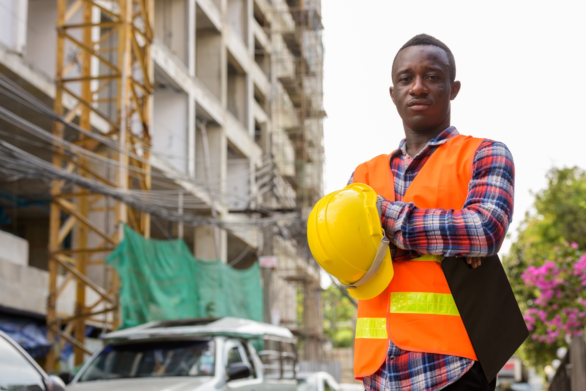 Young black African man construction worker holding clipboard an